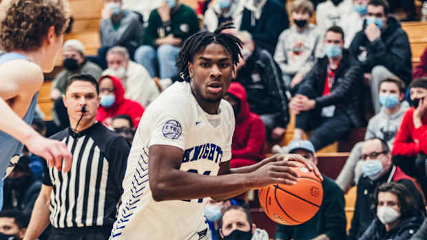 Mackenzie Mgbako holds a basketball in-game